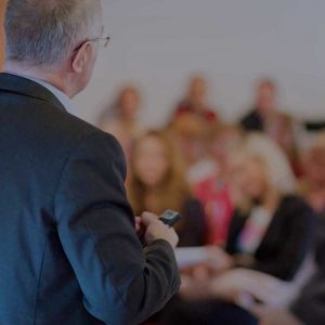 Speaker presenting in front of a room full of people